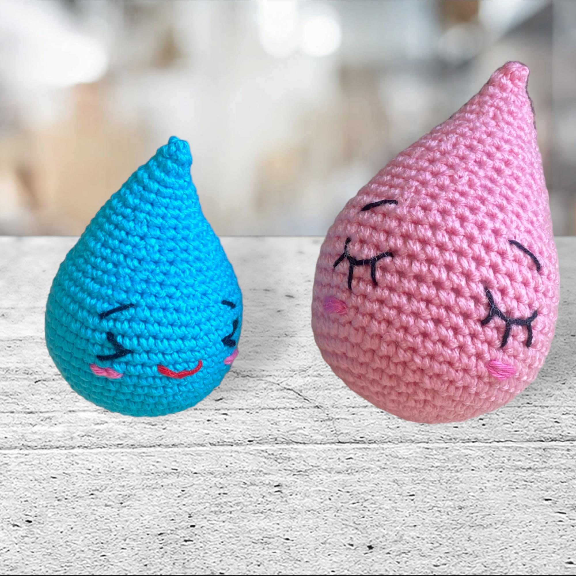 dos gotitas amigurumi, una pequeña color azul y una mas grande color rosa, con las caritas bordadas