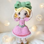 Muñeca tejida Lumi Éclair en ambiente natural con flores