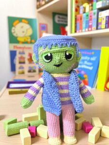 Instrucciones para tejer monstruo amigurumi Frankie en una habitación infantil