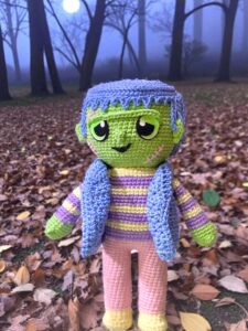 Tutorial de Frankie a crochet posando en un camino de hojas secas de otoño