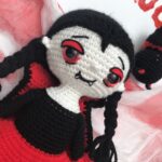 Primer plano del rostro tejido de Isobel la vampira destacando sus ojos y colmillos